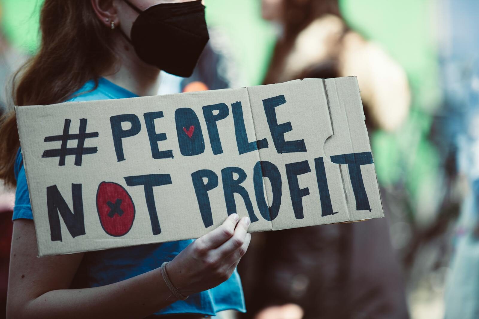Street protest highlighting social justice with a People Not Profit sign.